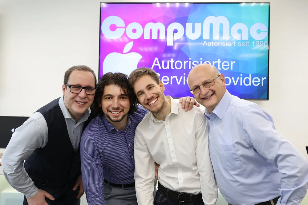 Four people from the CompuMac team laughing into the camera together in the store.
