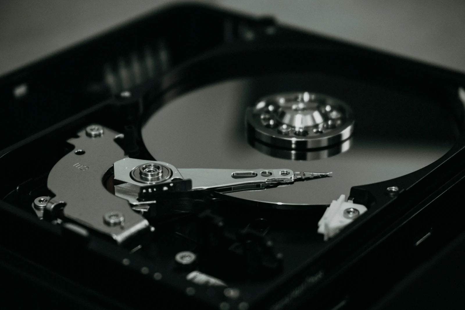 Opened hard drive showing the platter and the read/write arm