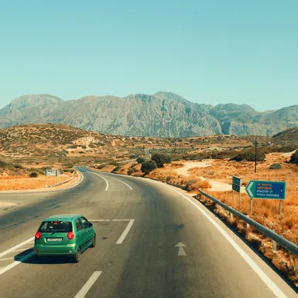 Car on a country road with mountains in the background
