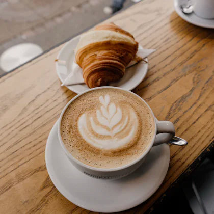 Cappuccino and croissant on a wooden table