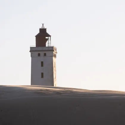 Lighthouse behind a sand dune