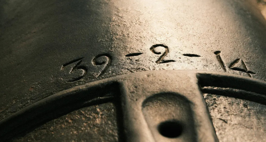 Close-up of old metal with the numbers 39-2-14 cut into it.
